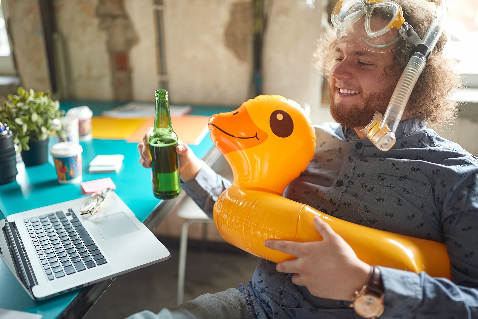 happy guy in office holding bottle and duck life preserver
