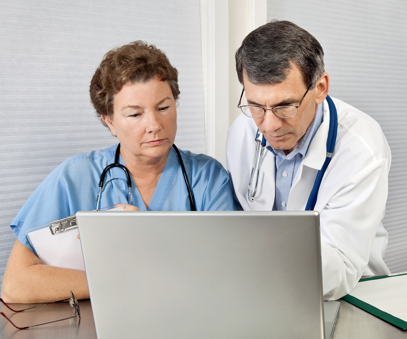 mature nurse and doctor looking at laptop